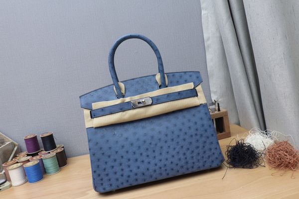 

by order,whosale fully handmade ostrich skin blue design purse 30cm,wax thread, have both gold and silver hardware,contact me for details