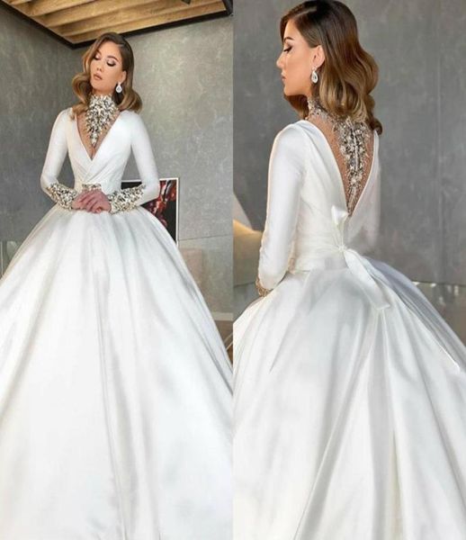 

2020 dubai arabic high neck satin ball gown wedding dresses sparkly crystals beaded v neck long sleeve illusion back bridal gowns 8222576, White