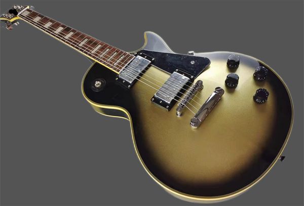 

custom lp electric guitar, yellow logo and yellow bindings, vintage silver, silver accessories, bright lights, mahogany body, stock