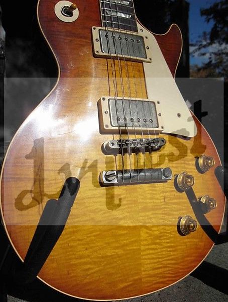 

electric guitar with flame relic finished and old aged parts small pin bridge.cherry burst