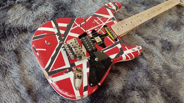 

Striking Red Electric Guitar: Bold Black/White Geometric Patterns & Metallic Tremolo