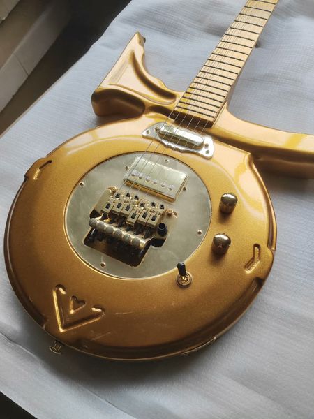 

Striking Ornate Gold Electric Guitar: Unconventional Rounded Body, Swirling Arm Extension, Metallic Hardware