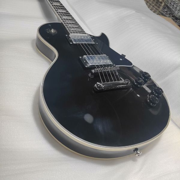 

Sleek Black Gloss Single-Cut Electric Guitar: Transparent Humbuckers, Tune-O-Matic Bridge, Black Pickguard