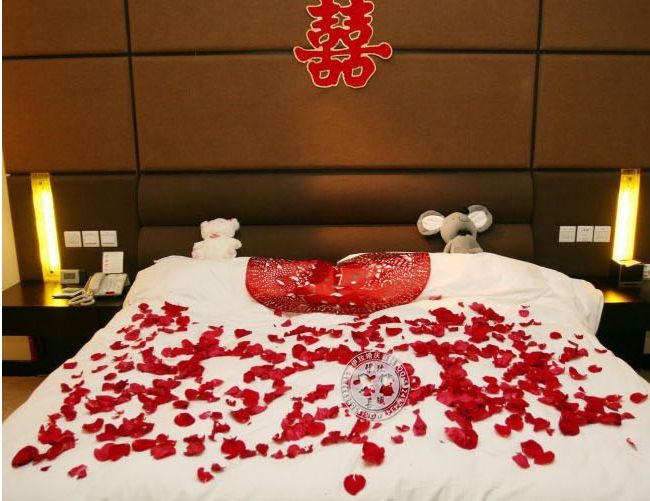 лепестки роз. кровать для брачной ночи. кровать усыпанная лепестками роз. лепестки роз. лепестки на кровати.