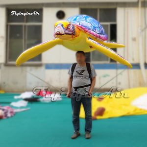 Attrayant adulte transportant coloré de grandes marionnettes gonflables de marine de mer souffle un ballon d'animaux de mer pour un spectacle de défilé