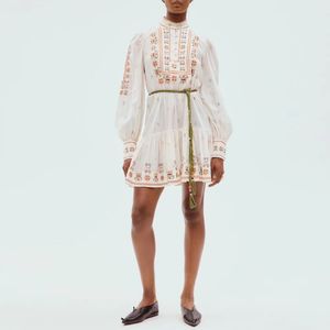 Australische designerjurk Witte katoenen mini-jurk met opstaande kraag, lange mouwen en geborduurde bloemen