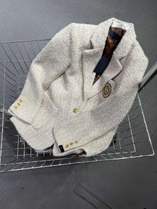 Manteau en laine avec petit insigne de parfum pour femmes d'automne et d'hiver, tissu en laine tissé sur mesure, tissu d'emballage de bord en soie à épissage intérieur, version ajustée de la mode.
