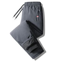 Pantalones de otoño para hombre cintura elástica fitness ropa deportiva invierno impermeable y cálido tamaño grande suelto abajo 7xl 240309