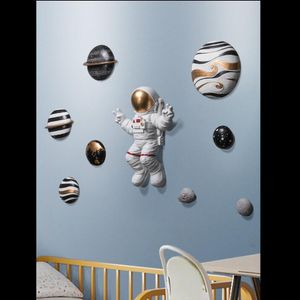 Kinderkamer versierd met astronaut decoratieve objecten wanddecoratie nachtkastje achtergrond muur hangers driedimensionale hanger