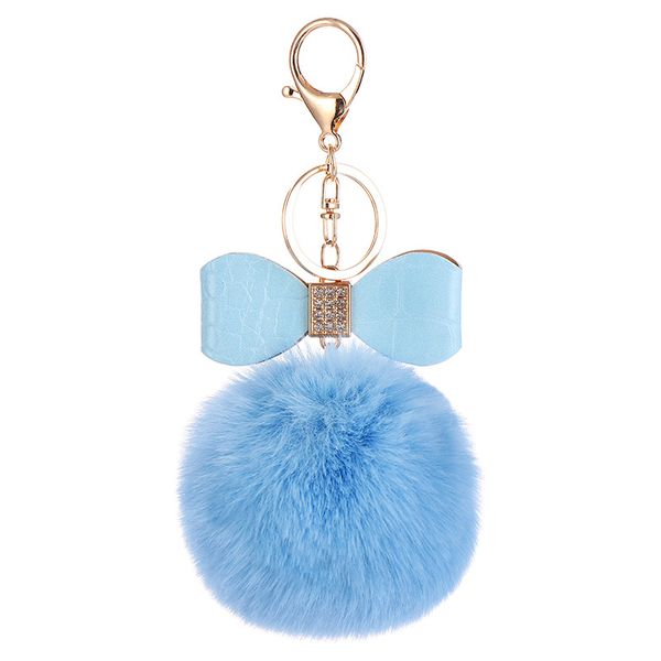 Porte-clés bouffée de fourrure de conception classique en forme de boule en peluche Pom or en cuir noeud papillon porte-clés pour enfants femmes