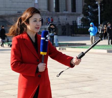 美女记者在用日前,小米科技ceo雷军参加两会期间,在人民大会堂前用