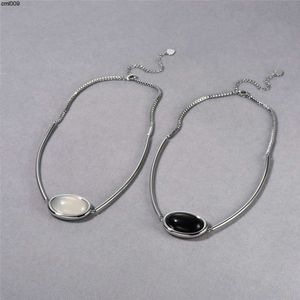 Estilo frío e indiferente Collar con colgante de ágata negra de médula de jade blanco con incrustaciones ovaladas de platino chapado en cobre de metal minimalista de alta gama