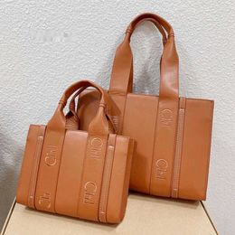 Bolsas de cosméticos Estuches Woody Tote Bolso de compras Bolsos cruzados para mujer Bordado de letras de cuero de vaca Cierre magnético Bolsillo de gran capacidad Monedero grande de color sólido