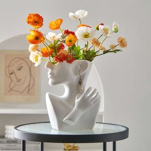Creatieve moderne minimalistische portretkunst in Scandinavische stijl, bloemstuk in de woonkamer, gepersonaliseerde keramische vaas, woondecoratie en ornamenten