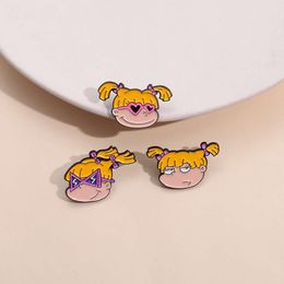 Creatief geelharige kleine meid met cartoon anime -ontwerp, legeringsbadges rond de randen, gepersonaliseerde trendy en coole vaste sjaal gesp.