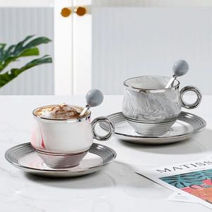 Kopjes schotels middeleeuwse koffiekopje en schotel set stenen textuur met lepel moderne eenvoudige keramische teaset thuis drinken