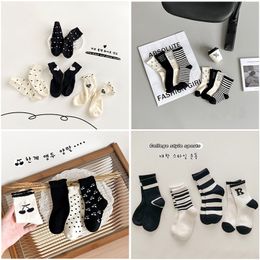 Diseño Wave Point Niños pequeños Bebé Alta calidad Nuevos niños Niñas Moda Niños grandes Calcetines de algodón transpirables Calcetines de tubo medio a rayas en blanco y negro