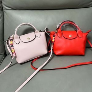 Designer tas hoogwaardige nieuwe Franse mini -koehide kralen Dumpling -tas kan worden gedragen op een schouder crossbody voor dameszak kralen penhouder tas