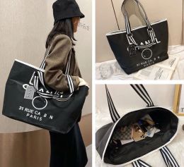 Marques de créateurs noir blanc sacs à provisions femmes Triangle étiquette étanche loisirs sac de voyage grande capacité en nylon maman fourre-tout P230325fu75