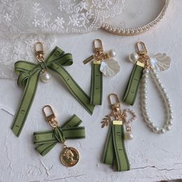 Bolso de cadena de diseñador para mujer, llavero de coche, abalorio de perla, cinta verde, llavero de conchas delicadas, colgante para pareja, regalo, bonito