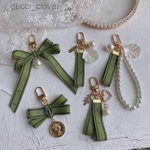 Diseñador llavero de llave de llave de llavero encanto carpeta de coche hembra anillo perla encanto de perla cinta verde conchas delicadas con llavero parto regalo bien bueno