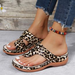 Des pantoufles léopard européennes et américaines impriment des chaussures décontractées portant des talons inclinés et des sandales de plage en forme de T à fond plat pour femmes