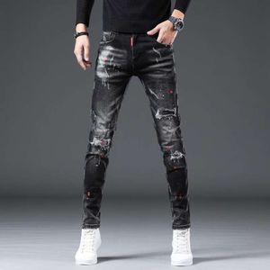 Calça jeans masculina europeia e americana com estampa de pintura preta e cinza rasgada com remendo elástico para pés