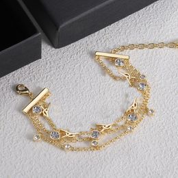 Explosivo diseñador senior crea una pulsera en forma de Y. Una pulsera de lujo con piedras preciosas y diamantes de oro para la querida madre y la familia.
