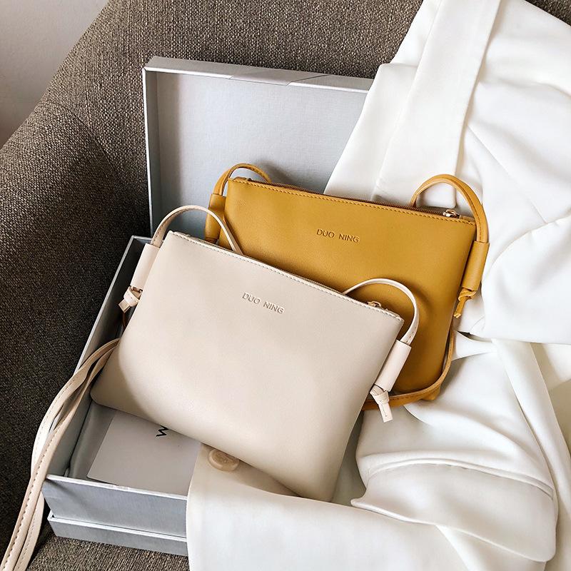 

Small square bag slung over one shoulder
