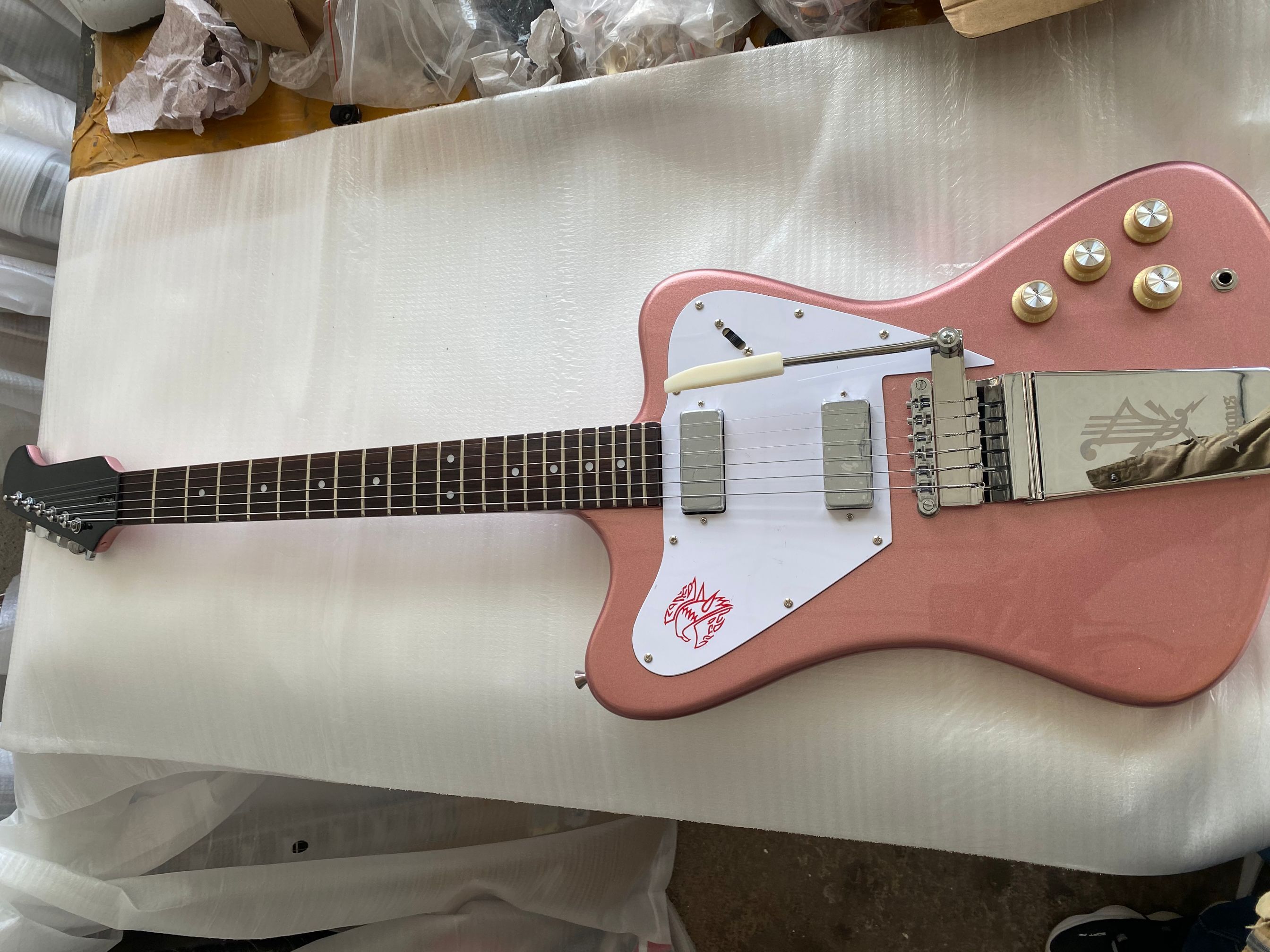 

Custom Non Reverse Fire Thunderbird Rose Gold Electric Guitar Long Maestro Vibrola Tremolo Bridge, Mini Humbucker Pickups, Eagle Pickguard, Chrome Hardware
