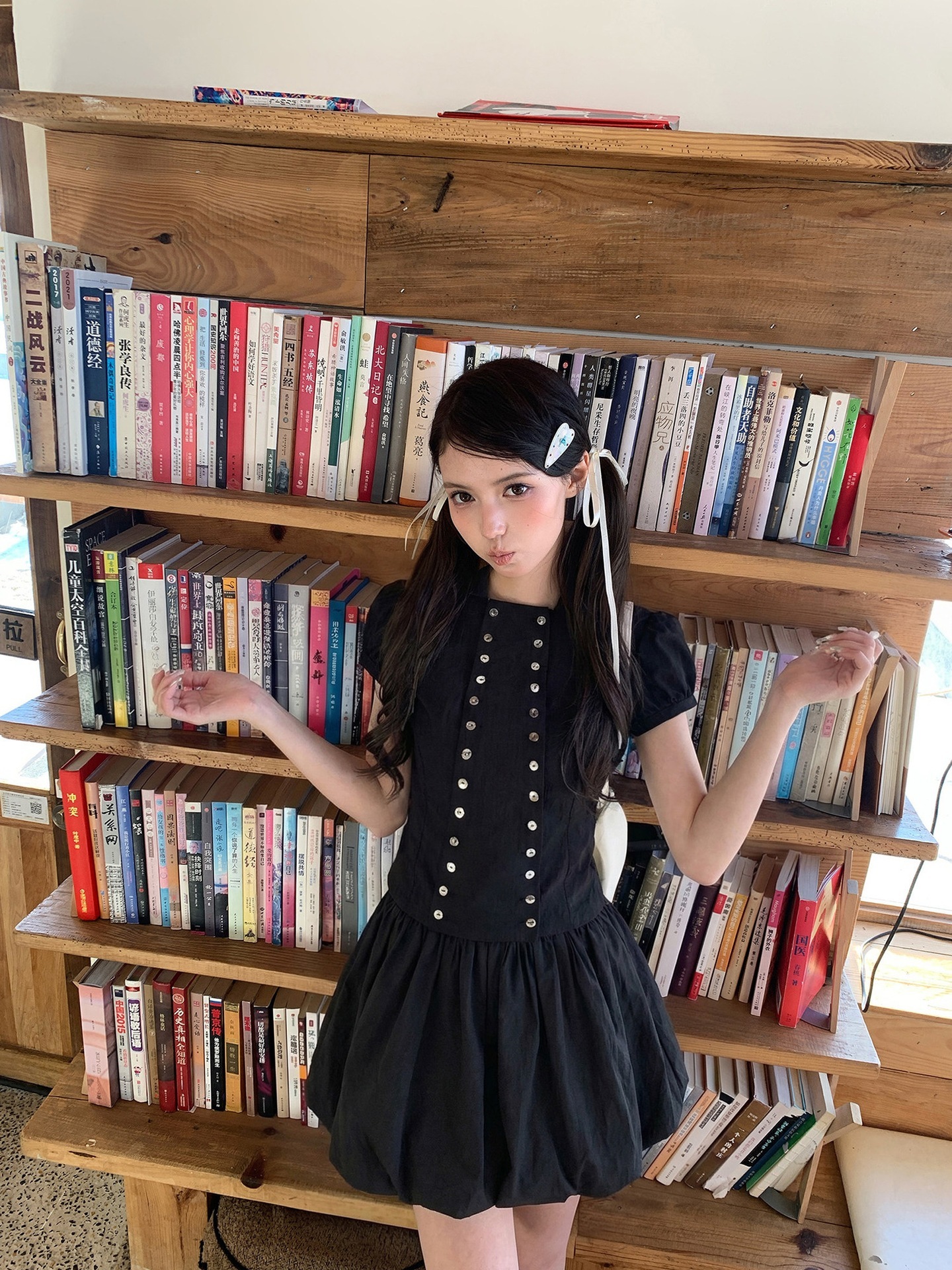 Black, fitted, and slimming puff-sleeve shirt for women, paired with a short black floral-print skirt and shorts set, perfect for summer