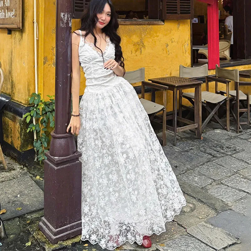 Abito lungo scavato in pizzo bianco per le donne Abito coreano chic a vita alta sottile con cinturino per spaghetti Abito da festa sexy con scollo a
