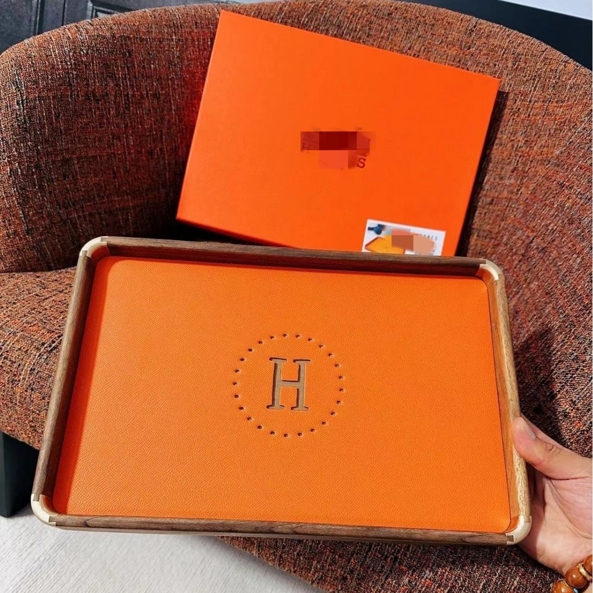 Designer jewelry storage tray with compartments, featuring luxurious charm in orange leather and walnut wood. High-end wooden jewelry box for storin