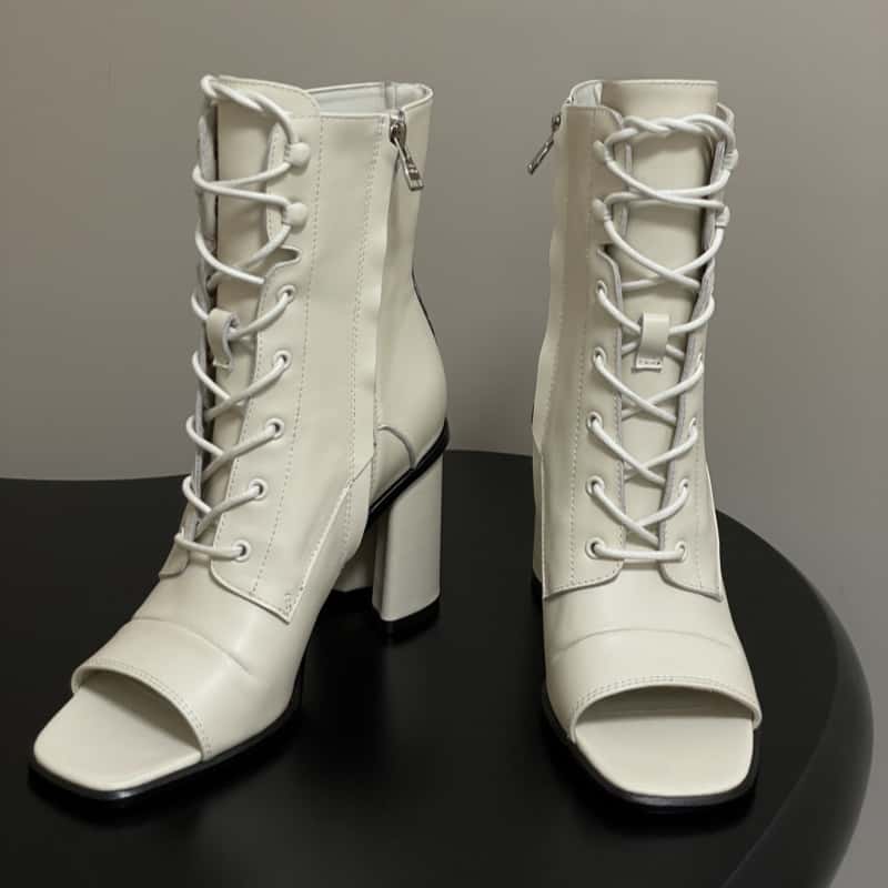 Bottes fraîches de la bouche neuve du début de l'automne avec des talons hauts à lacets et des fermetures à glissière latérales épaisses