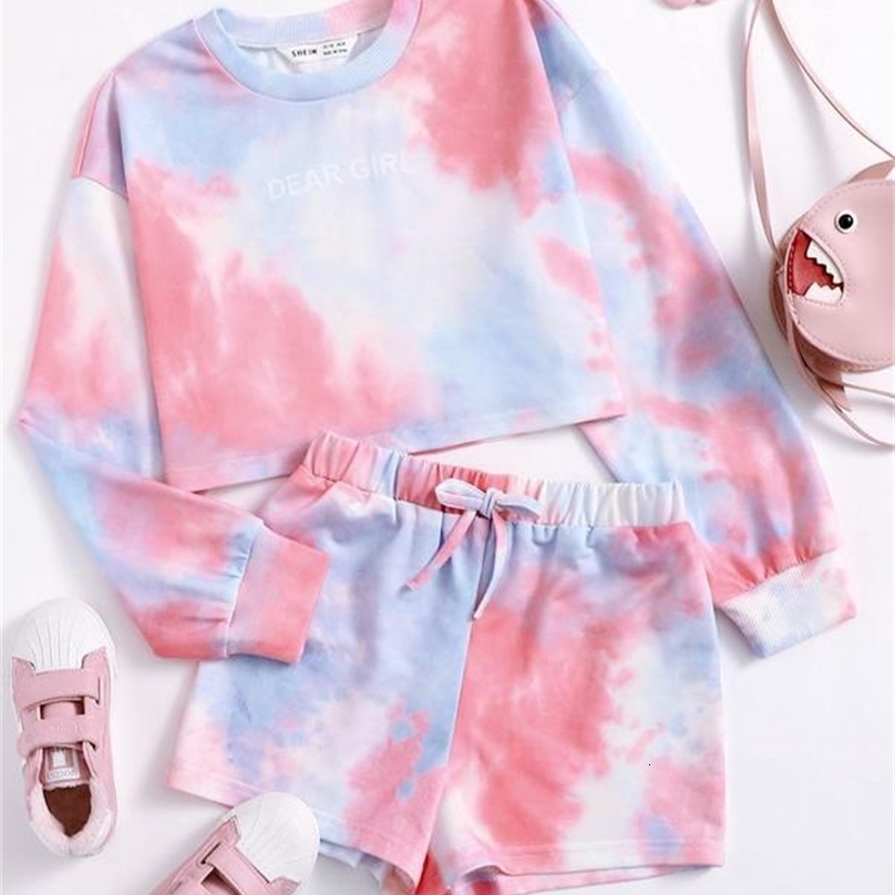 Les filles lient le pull graphique de la lettre de teinture et les shorts elle