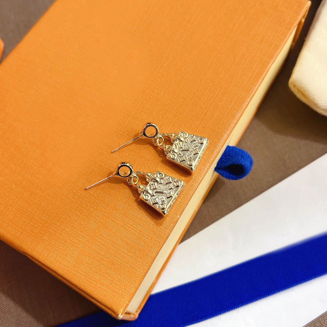 Boucles d'oreilles pendantes en forme de mini sac doré avec détails texturés, bijoux de fête chic pour elle, haute qualité et design élégant