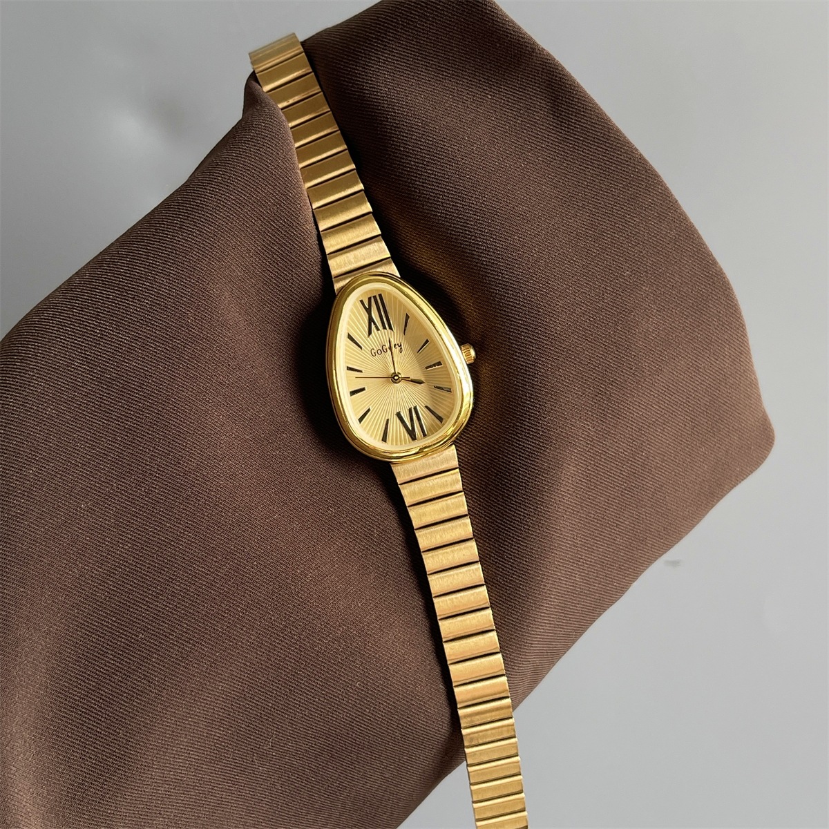 Montre de luxe pour femme avec cadran ovale irrégulier doré, bracelet en métal doré rayé et chiffres romains, montre rétro quotidienne, accessoir