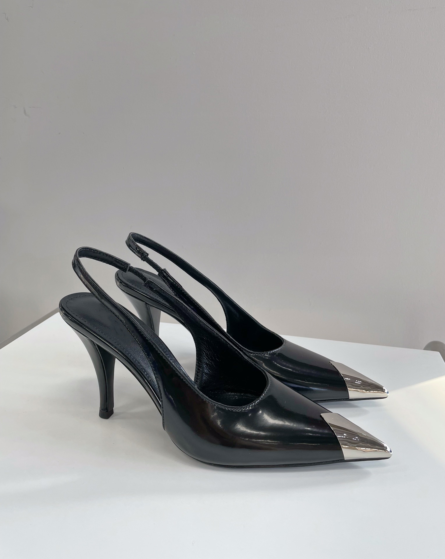 Les éléments en cuir des brevets sont associés à des talons aiguilles en pointe métallique, des sandales creuses, des robes de bureau professionn