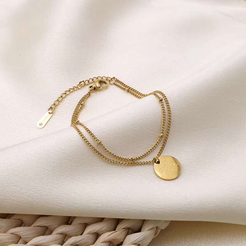 DHCollections Bracelet à pendentif rond en acier inoxydable plaqué or, design minimaliste, chaîne à breloques avec lettres gravées, bijoux pour f