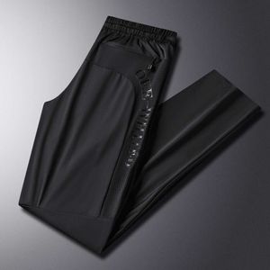 Pantalon décontracté de ventes directes d'usine pour hommes avec de la soie de glace, des sports d'été lâches, des liens de jambes élastiques, des pantalons recraflés à respiration, légers et frais