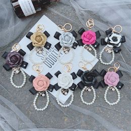 Nuevo llavero de Camelia con lazo, cadena de perlas creativa, bolso de cuero PU con flores rosas, accesorios colgantes para llavero de coche 3131