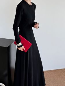 Sentant la torsion sur le dos de la robe haut de gamme, le style mi-long dégage une jupe inférieure en tricot coupe ajustée de style Hepburn.
