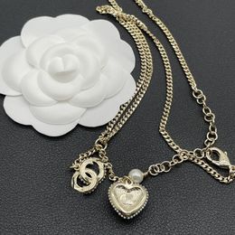 Une créatrice conçoit des boucles d'oreilles élégantes en or et en argent, un collier, un pendentif lettre pour femme à la mode et luxueux, des bijoux de conception spéciale de mariage