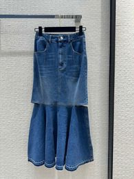 Jupe de jean de queue de poisson avec bord exposé et conception d'ourlet divisé