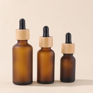 Bouteilles d'emballage cosmétique en verre brun givré avec compte-gouttes et couvercles en bambou