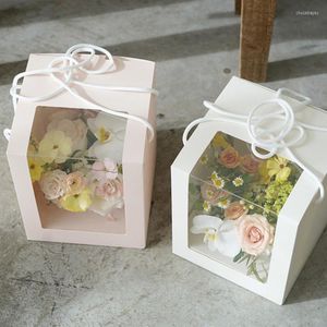 Emballage cadeau boîte carrée transparente tenue dans la main avec fenêtre emballage de fleurs fraîches pour l'anniversaire de mariage de fête de festival