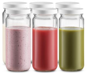 Glazen sapflessen met doppen heldere drankcontainers voor het sap smoothie drinken