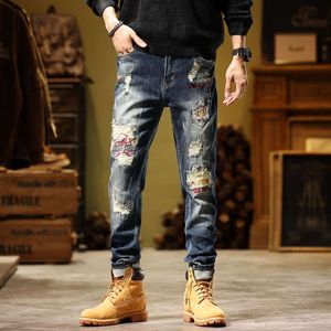 Knappe en gepersonaliseerde nieuwe gescheurde patch geschraapte heren jeugd elastische kleine voeten Koreaanse versie retro gescheurde jeans