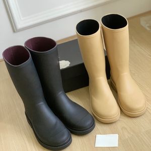 Botas de lluvia altas de alta calidad Media pantorrilla Negras Beige Medias botas Punta redonda Tacón plano Logotipo en el frente Suela de goma Diseñadores de lujo para mujeres Zapatos casuales Calzado de fábrica