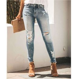 Les jeans de trous regardent avec un pantalon en jean de monture et des petits pieds mincerants pantalon femmes jean